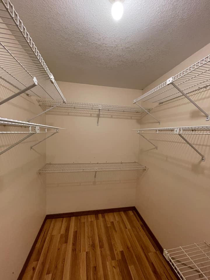 Builder-grade white wire shelving in an empty closet before a custom Tina's Closets installation